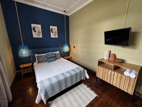 a bedroom with a bed and a flat screen tv at awā San José in San José