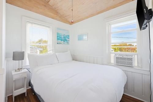a white bedroom with a bed and a window at Beach Home With Beautiful Ocean Views in Dennis