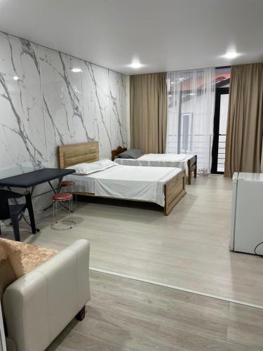 a hotel room with two beds and a table at Blue Horizon in Grigoleti