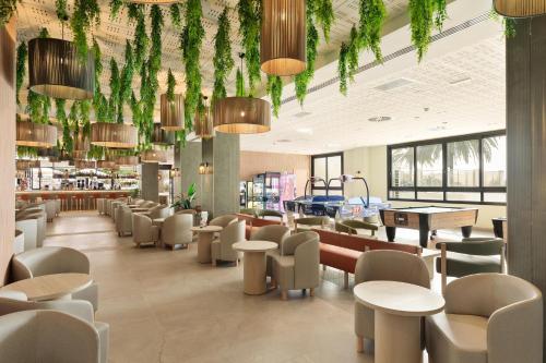 a restaurant with tables and chairs and plants at Hotel Best Siroco in Benalmádena