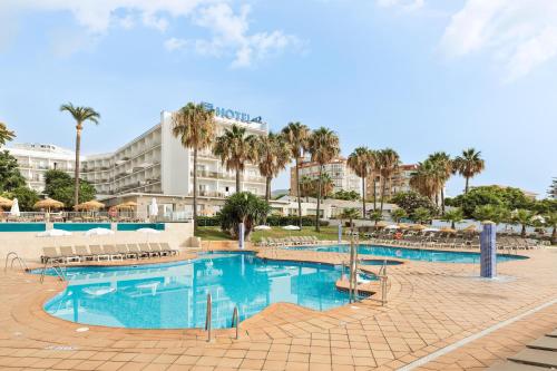 a large swimming pool with a hotel in the background at Hotel Best Siroco in Benalmádena