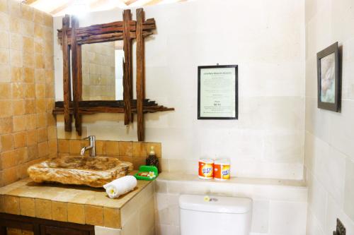 a bathroom with a sink and a toilet at Lovina Beachhouse Villas in Lovina