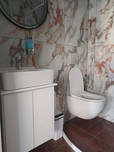 a bathroom with a white sink and a toilet at LA.KI House in Kavála