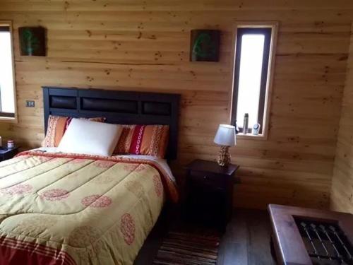 a bedroom with a bed in a log cabin at Casa Monita in El Quisco