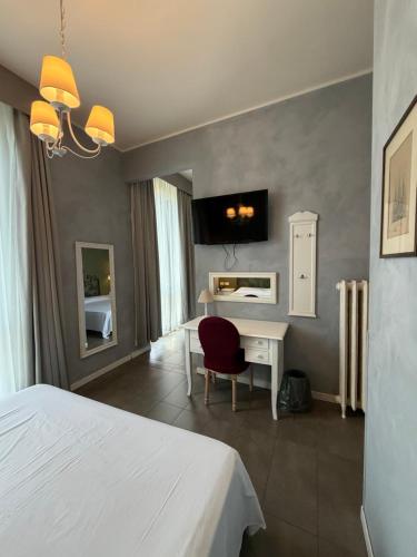 a bedroom with a bed and a desk with a chair at Boutique Hotel Washington Milano - JCUBE HOTELLERIE in Milan