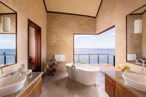 a bathroom with two sinks and a tub with a view at Four Seasons Resort Peninsula Papagayo, Costa Rica in Papagayo, Guanacaste