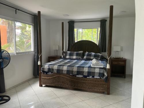 a bedroom with a bed with a blue and white blanket at HUMMINGBIRD Hotel Cabarete in Cabarete