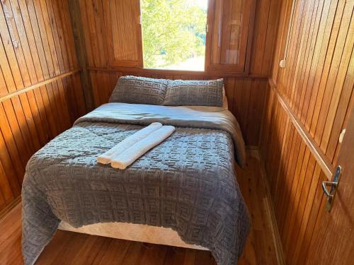 a small bed in a room with a window at CABANAS BELVEDERE SERRA DO RiO DO RASTRO in Lauro Müller