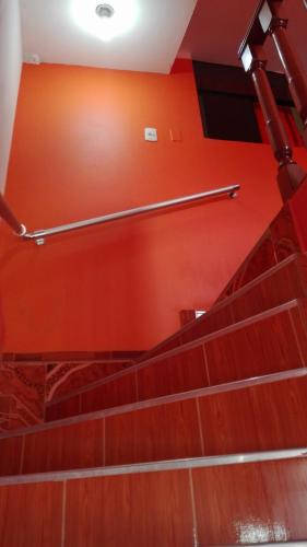 an empty staircase with red walls and metal hand rails at Residencial Norandes in Huaraz