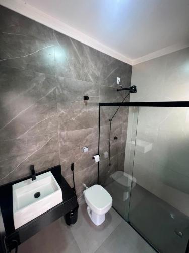 a bathroom with a sink and a toilet at Alefhouse in Bauru