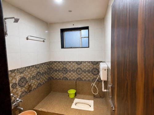 a bathroom with a toilet and a window at Sunset View in Mahabaleshwar