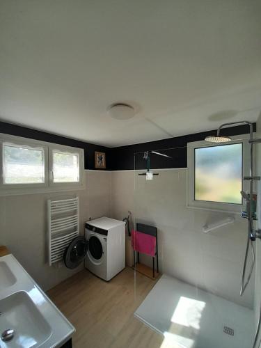a bathroom with a sink and a washing machine at Le clos de Tallann in Guénin