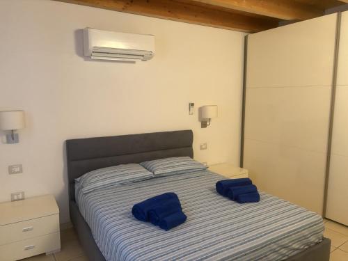 a bedroom with a bed with blue pillows on it at Casa Mare Teulada Sardegna in Teulada