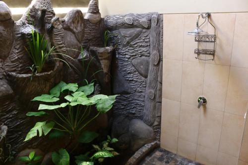 a shower in a bathroom with a fish tank at Lovina Beachhouse Villas in Lovina