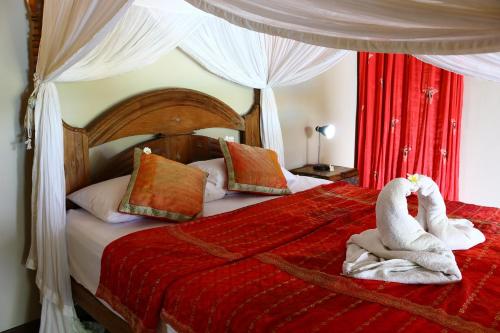 a bedroom with a bed with two swans towels at Lovina Beachhouse Villas in Lovina