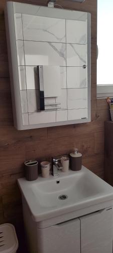 a bathroom with a white sink with three candles on it at Emperus Taša spa apartman in Veliko Gradište