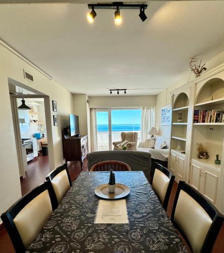 ein Esszimmer mit einem Tisch und ein Wohnzimmer in der Unterkunft Boulevard 10 - Dúplex frente al mar con balcón y vista panorámica in Puerto Madryn
