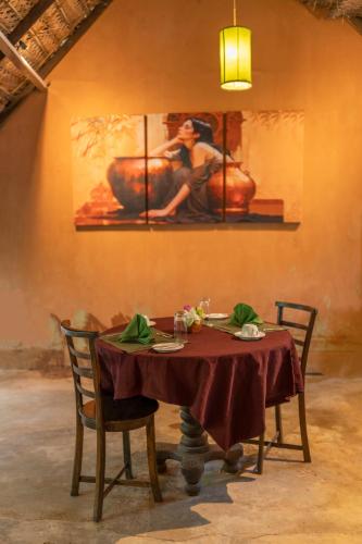 a dining room with a table and a painting on the wall at A4 By Gabaa in Habarana