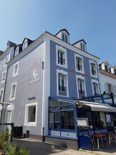 a blue building with a bus parked in front of it at Hotel Atlantique in Le Palais