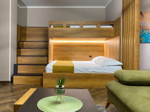 a bedroom with a bed with a wooden headboard at EKA Luxury Beachfront Apartments in Vlorë
