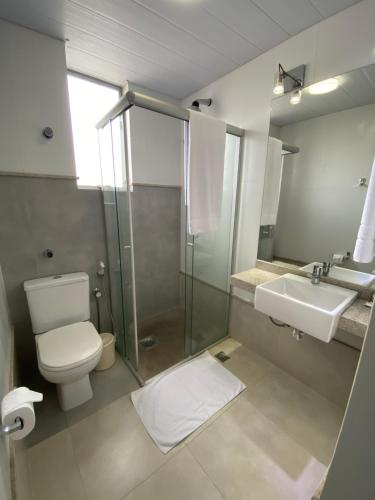 a bathroom with a shower and a toilet and a sink at JB Palace Hotel in Divinópolis