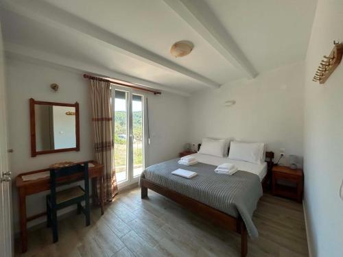 a bedroom with a bed and a desk and a mirror at Elia House in Skopelos Town