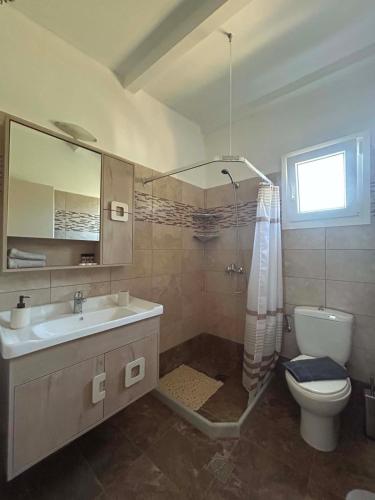 a bathroom with a sink and a toilet and a shower at Elia House in Skopelos Town