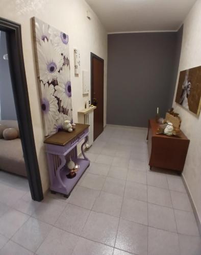 a hallway with a purple table and flowers on the wall at B&B Angelo Azzurro in Carpi