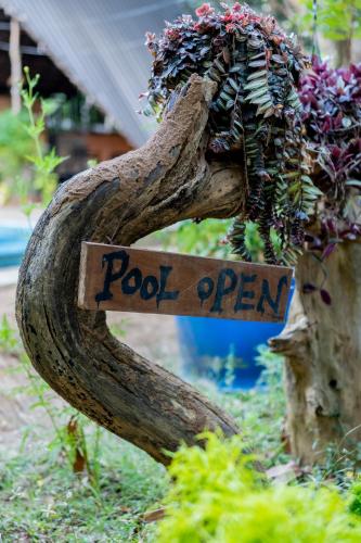 a sign that says pool open in a garden at A4 By Gabaa in Habarana