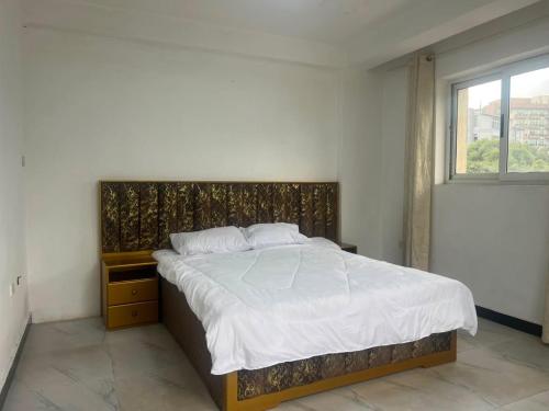 a bedroom with a large bed with a window at Casablanco Addis in Addis Ababa