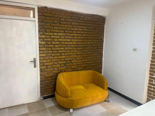 a yellow chair sitting in front of a brick wall at Casablanco Addis in Addis Ababa