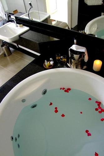 a bathroom with a bath tub with red hearts on it at Oratório Pousada Boutique in Tiradentes