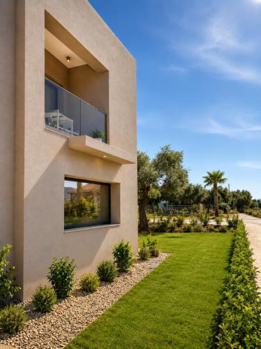 a house with a green lawn in front of it at Minimal Suites in Skala Rachoniou