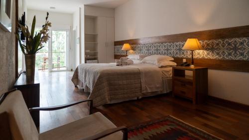 a bedroom with a bed and a table with two lamps at Oratório Pousada Boutique in Tiradentes