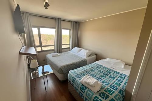 a hotel room with two beds and a window at Departamento en Calama in Calama