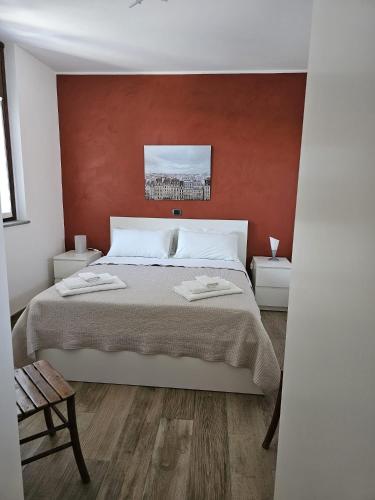 a bedroom with a large bed with a red wall at Mirtillo & Margot in Cambiano