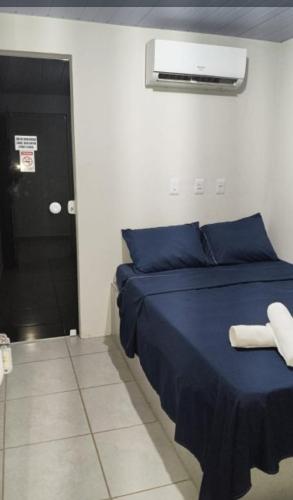 a bedroom with a blue bed with towels on it at suítes Arco-íris in Uberlândia