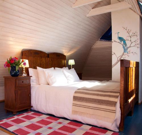 a bedroom with a large bed with a wooden headboard at Adami Country Guesthouse in Vainupea