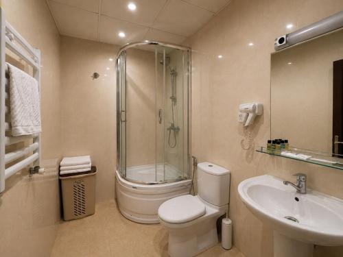 a bathroom with a shower and a toilet and a sink at Azcot Nizami Hotel in Baku