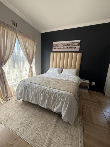 a bedroom with a large bed and a large window at The Precinct Lifestyle in Midrand