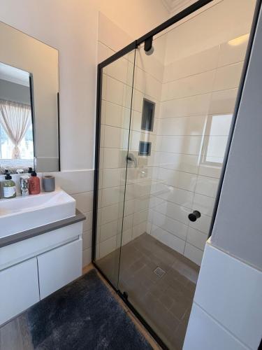 a bathroom with a glass shower and a sink at The Precinct Lifestyle in Midrand