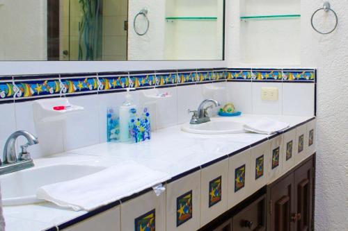 a bathroom with two sinks and two mirrors at Villa Siros de 4 habitaciones in Chicxulub