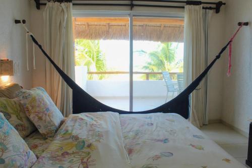 a bed with a hammock in a room with a window at Villa Siros de 4 habitaciones in Chicxulub