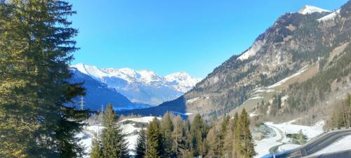 a view of a mountain valley with snow covered mountains at Energy Lodge in Kandersteg