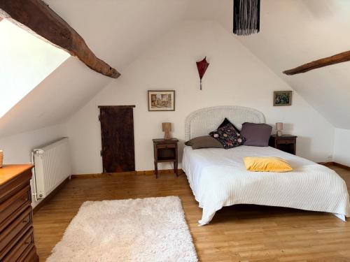 a bedroom with a white bed and a wooden floor at Gite d'Aimelles in Billezois