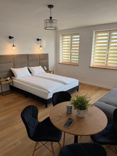 a bedroom with a bed and a table and chairs at Villa Bianca in Mikołajki