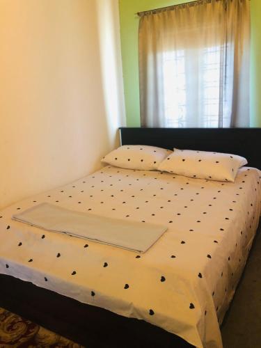 a bed with a black and white comforter and pillows at Trio Mango Stay in Arugam Bay