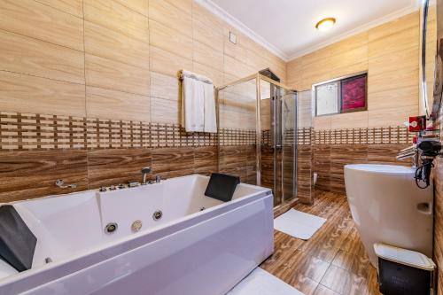 a bathroom with a large white tub and a shower at Moriah Hill Resort in Kibuye