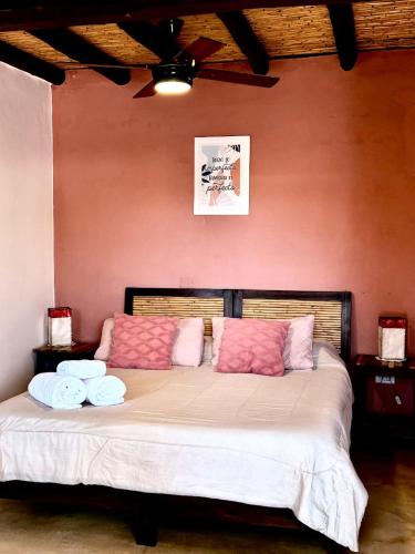 a bedroom with a large bed with pink and white pillows at Crisol. in Cafayate