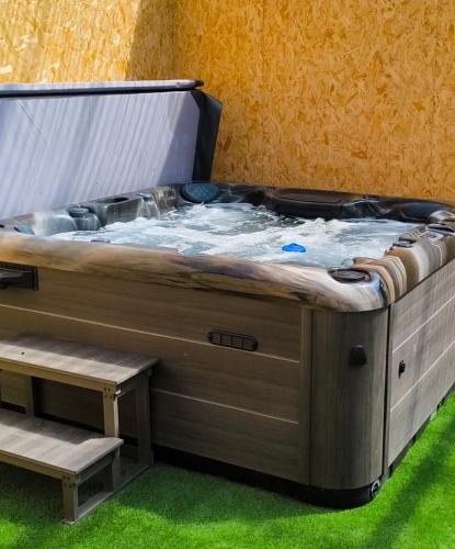 a large hot tub in a room with green grass at Canal View Lodge & Spa - Entire 3 Bed Lodge in Longford